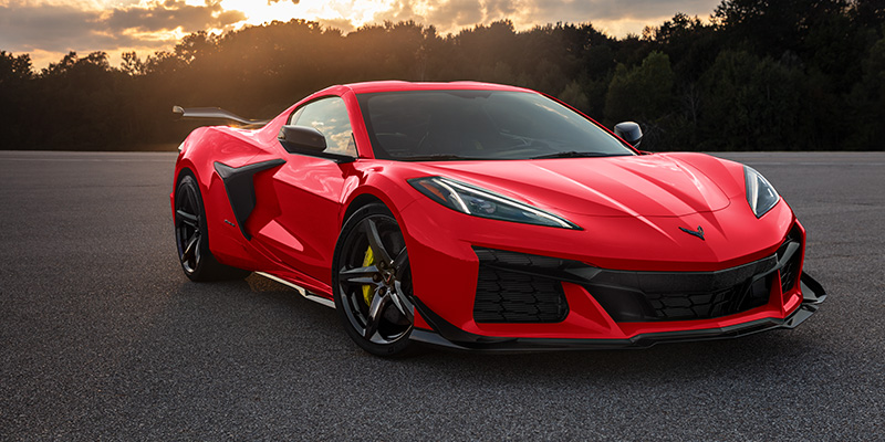 Red Chevrolet Corvette parked at sunset
