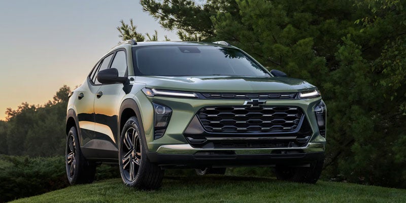 Chevrolet Trax SUV parked on grassy landscape near trees
